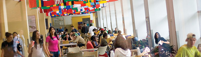 Students sitting at tables on Market Street underneath the display of flags above